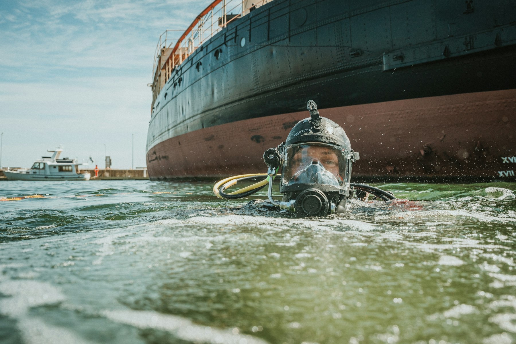 Commercial diver alongside a ship hull during a port call